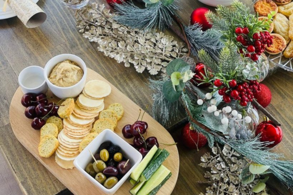 A cheese board on a table with Christmas decorations