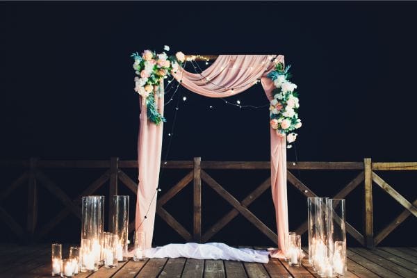 A wedding arbour at night with candles