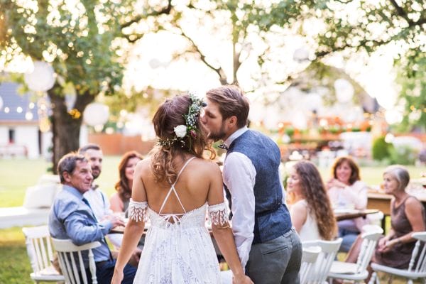 A couple kissing at an intimate backyard wedding