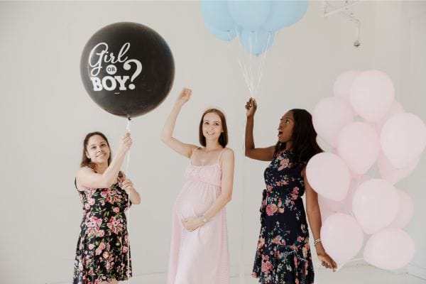 Friends about to pop a balloon to reveal the gender of a baby
