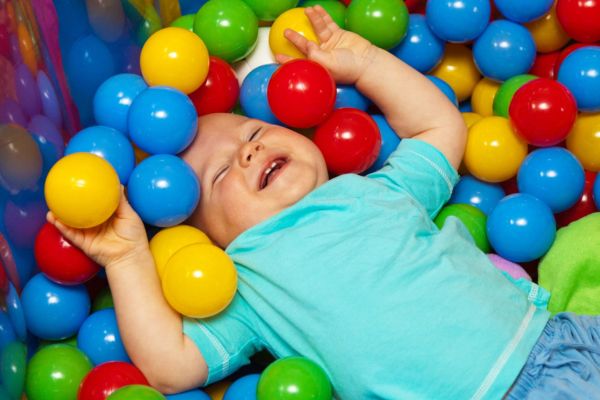 Child laughing in a ball pit