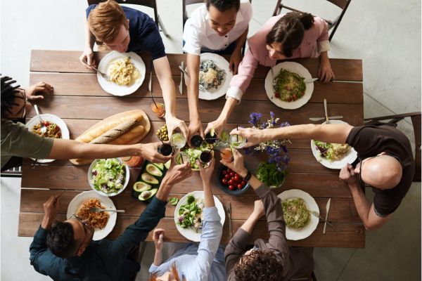 A group of friends cheersing over a dinner party table