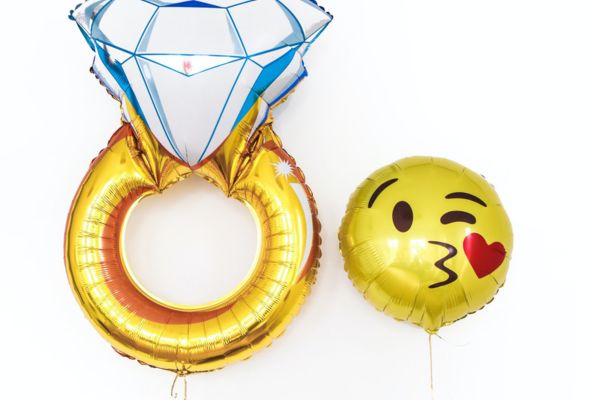 A ring and emoji balloon at an engagement party