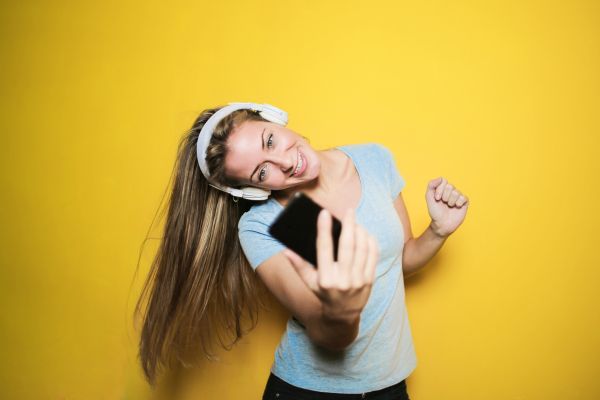 A girl dancing with headphones to a playlist