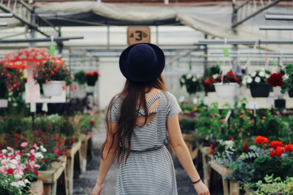 A bride-to-be walking the aisles of a flower market for wedding style inspiration