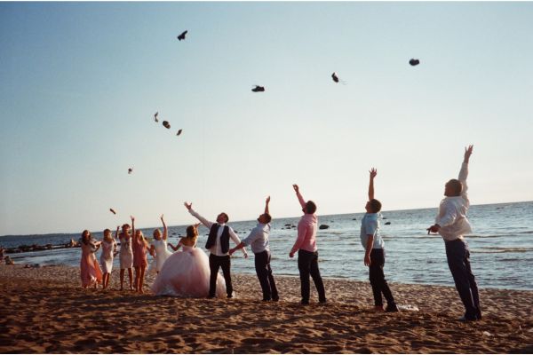 A wedding party celebrating on a beach after the ceremony