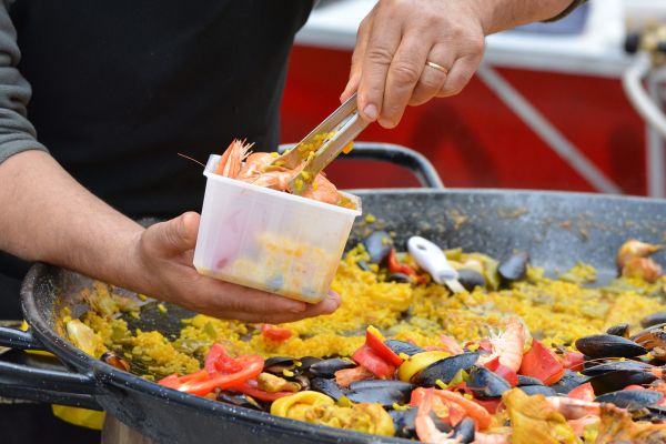A guest serving paella out of a paella pan