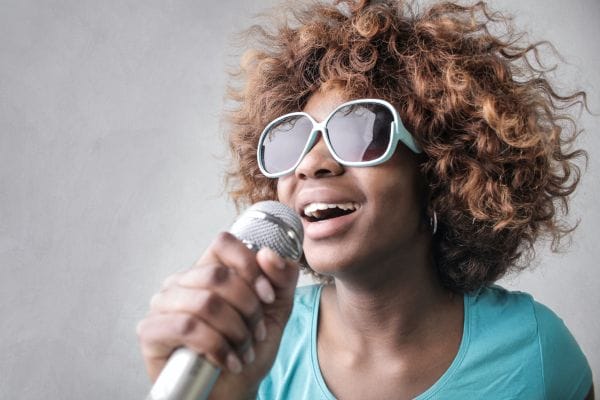 A lady on a microphone singing a karaoke number